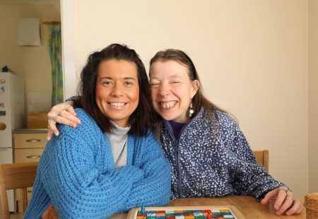 Two people smiling playing board game