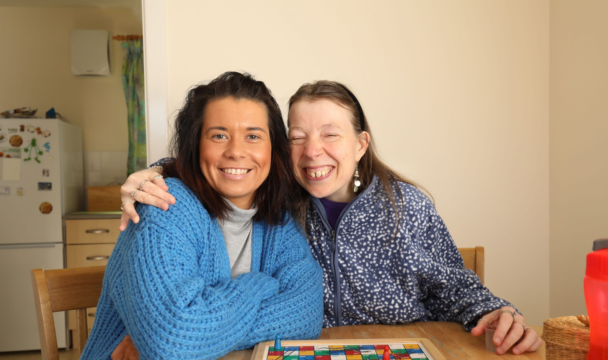 Two people smiling playing board game