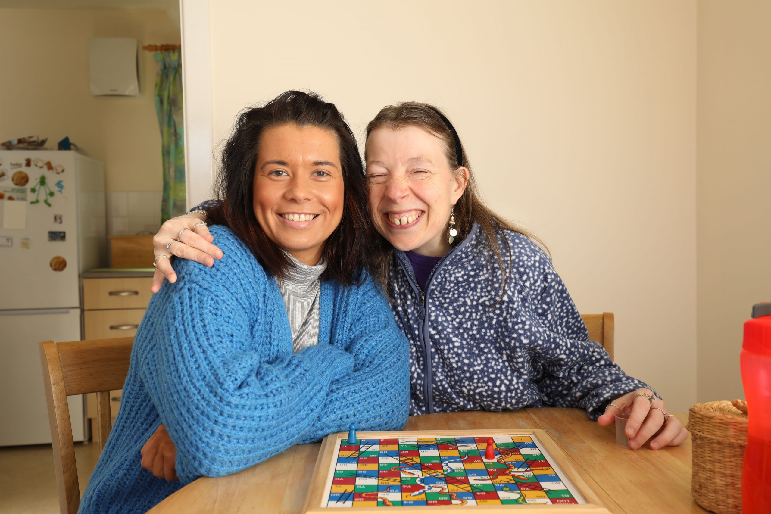 Two people smiling playing board game
