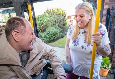 Man and woman smiling in vehicle.