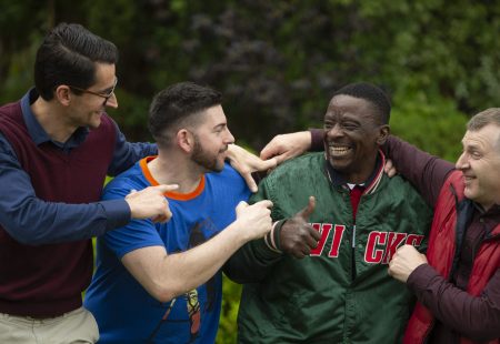 Group of four laughing with arms around each other, from Community Integrated Care, one of the UK's largest health and social care charities