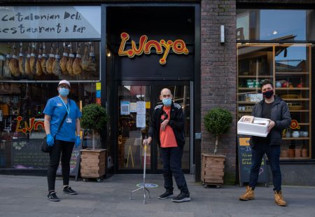Three people standing outside Lunya restaurant