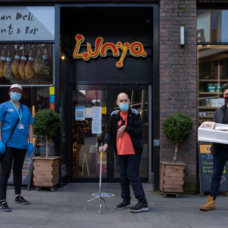 Three people standing outside Lunya restaurant
