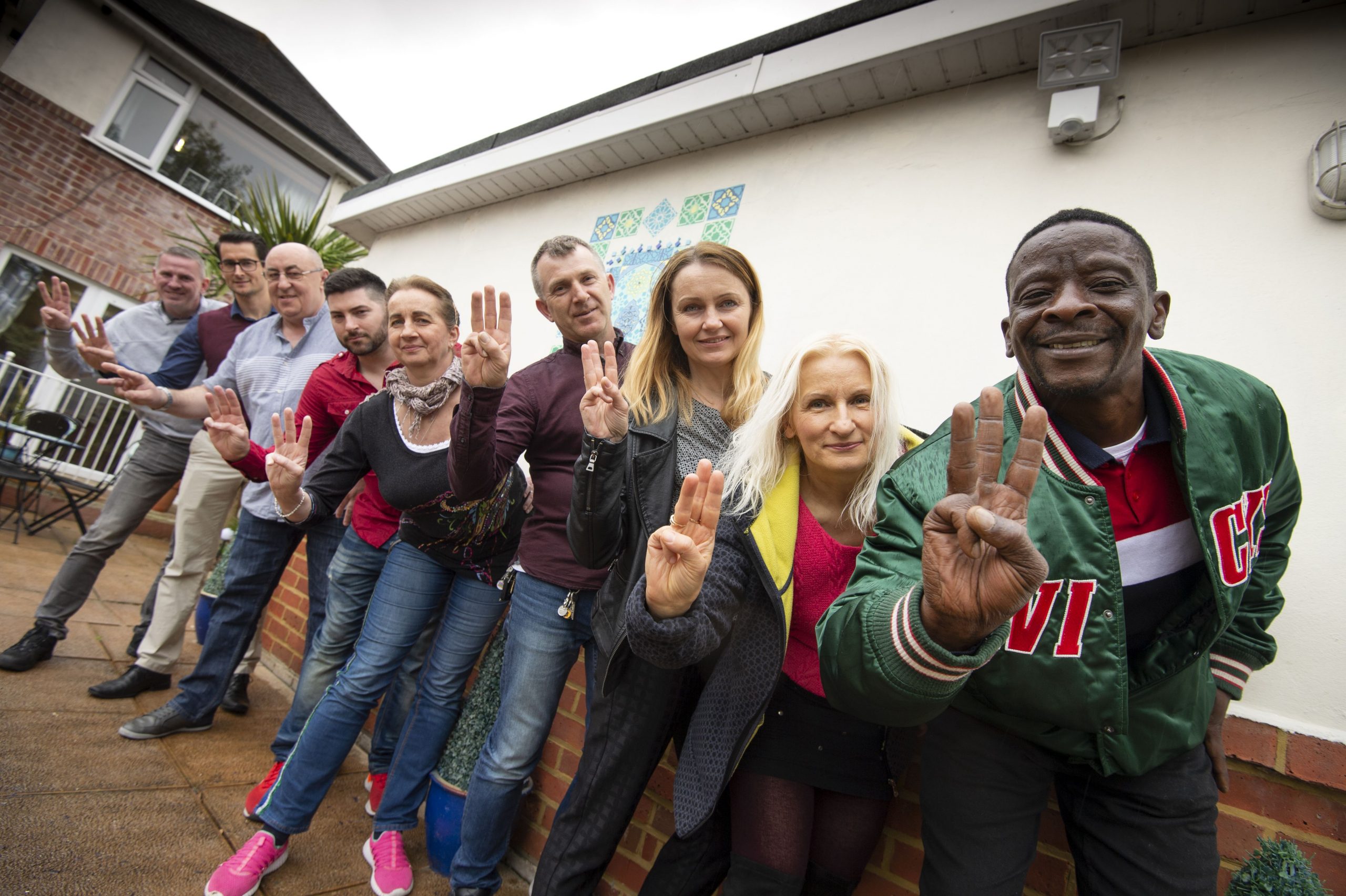 Colleagues leaning in doing the We Dare salute