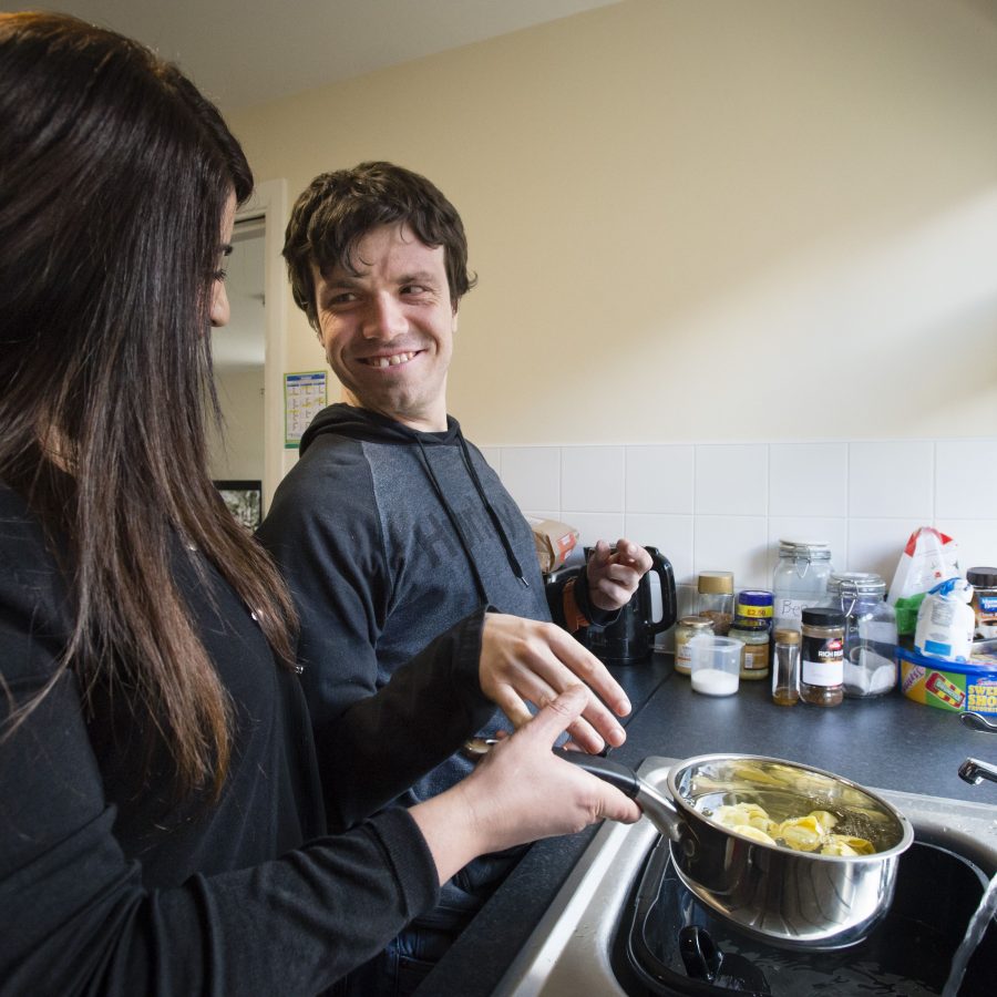 Person we support and colleague stood next to sink cooking