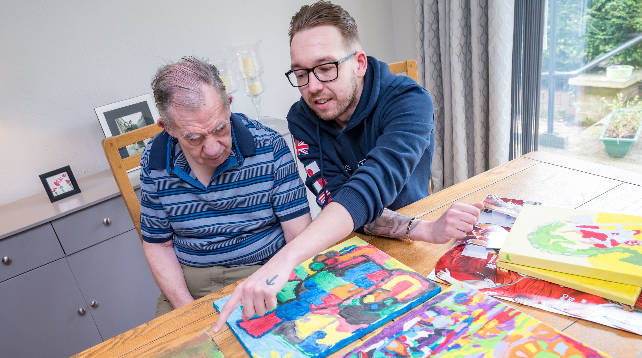 Person supported with colleague doing arts and crafts