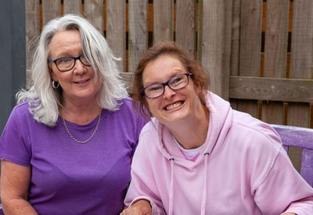 Person supported and colleague at table smiling