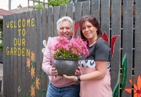 Woman and man holding flower pot