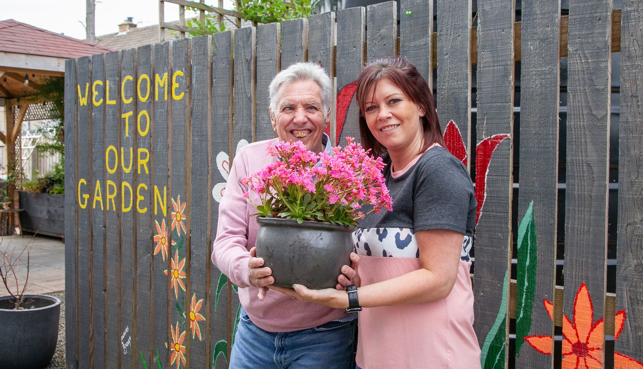 Woman and man holding flower pot
