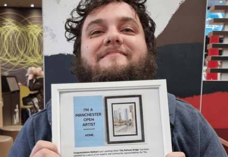 Natham Clapham holding his artwork for Manchester open.