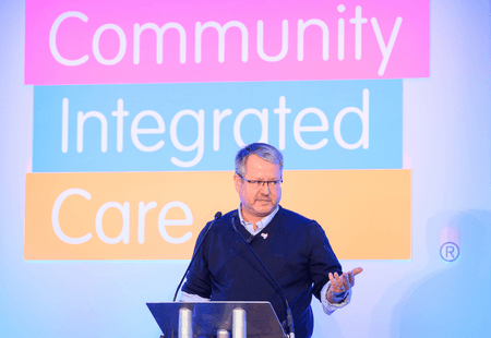 Mark Adams standing in front of the Community Integrated Care Logo.