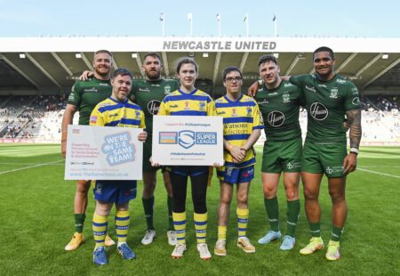 Group shot on Rugby League field holding up 'We're on the same team' posters