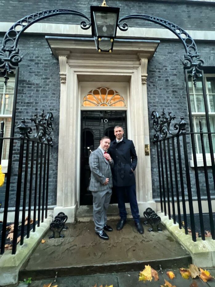 John and Oliver stand outside number 10 Downing St to celebrate Inclusive Volunteering®