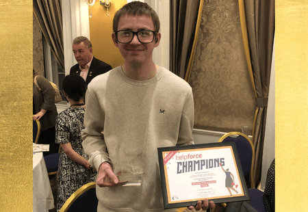 Matt Price, Inclusive Volunteer, holds the Helpforce Champion award and certificate