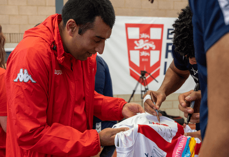 An Inclusive Volunteer from Community Integrated Care meets England layers and gets his shirt signed.