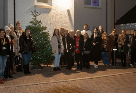 Colleagues and people supported at Brook Streeet stood next to their Christmas Tree.
