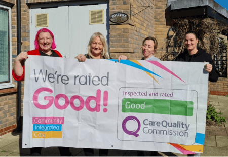 Members of the Rose Vale team holding a banner that reads, 'We were rated Good!'