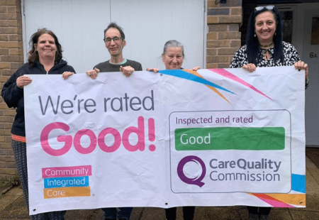 Colleagues and People supported at Sewells hold up a banner stating 'We're rated Good'