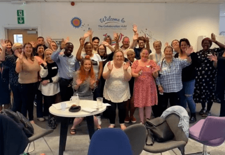 Group of colleagues cheer for Learn To Lead