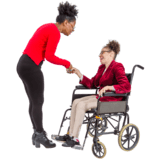 Woman standing, greeting a woman in a wheelchair.