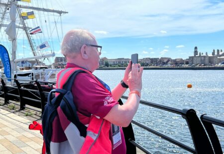 Inclusive Volunteer photographing Tall Ship event