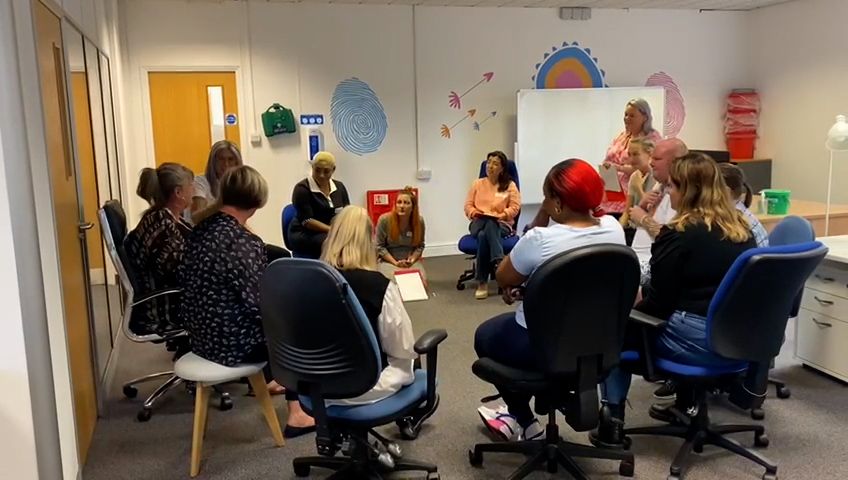 A group of colleagues sitting in a circle, taking part in a Learn To Lead workshop.