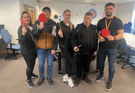 Colleagues and people supported by Community Itnegrated Care celebrate World Table Tennis Day, posing for a photo.