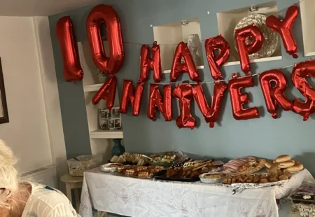 B10 year anniversary balloons hung up above a table of celebratory food