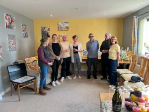 Pete standing with his loved ones beside his artwork