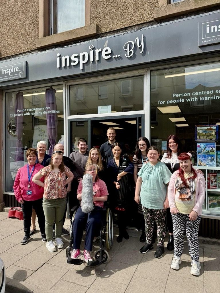 Community integrated Care colleagues and people supported by the charity standing outside the 'Inspire By' shop in Stonehaven.