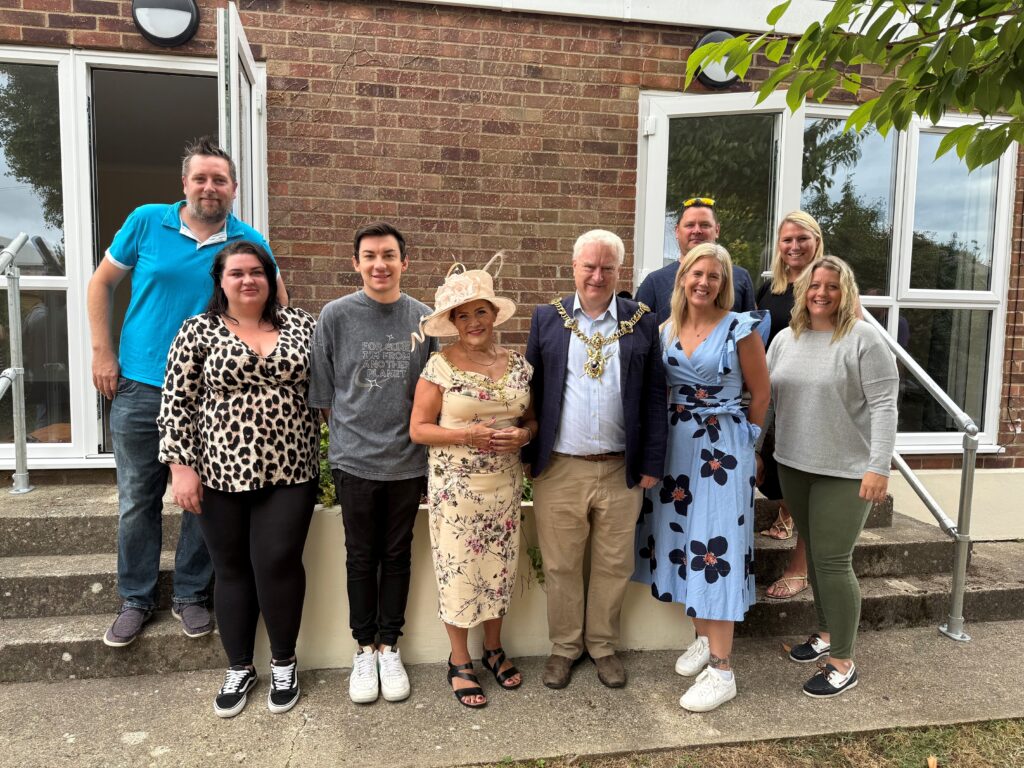 A group of people are stood together smiling at the camera