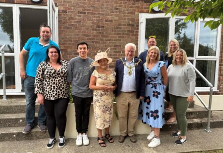 A group of people are stood together smiling at the camera