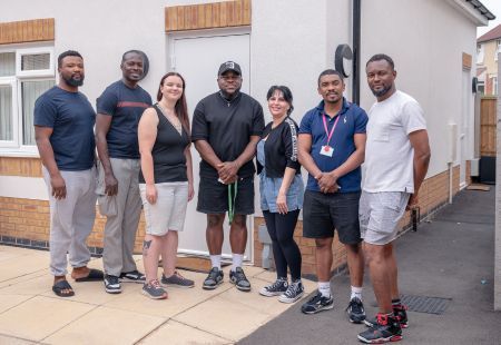 Colleagues from the Brickfields team stand outside the service, smiling to camera.