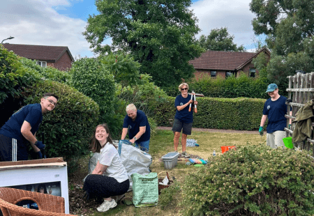 A photo of a happy group of people gardening on a sunny day.